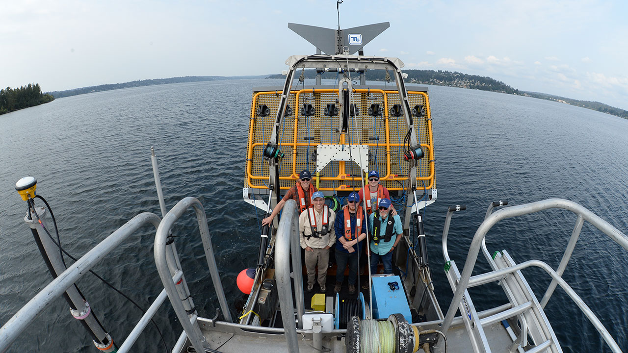 Cinq membres de l’équipage de levés bathymétriques de Tetra Tech posent avec Ultra TEMA-4, qui est utilisé pour la détection de munitions immergées et de munitions non explosées