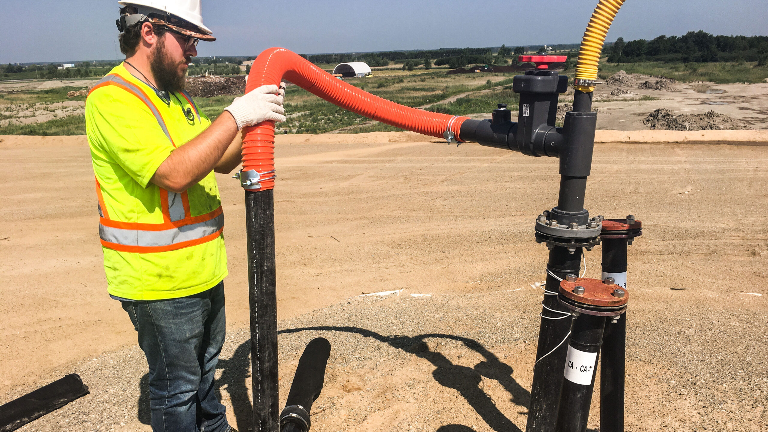 Travailleur de Tetra Tech en train d’installer une tête de puits de gaz d’enfouissement