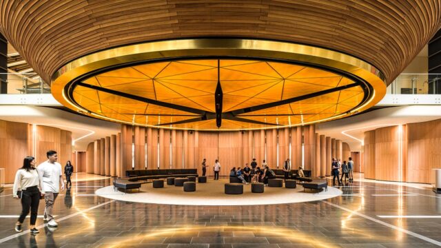 Hall de musée orné d’une grande sculpture lumineuse de plafond architectural surplombant un espace de places assises