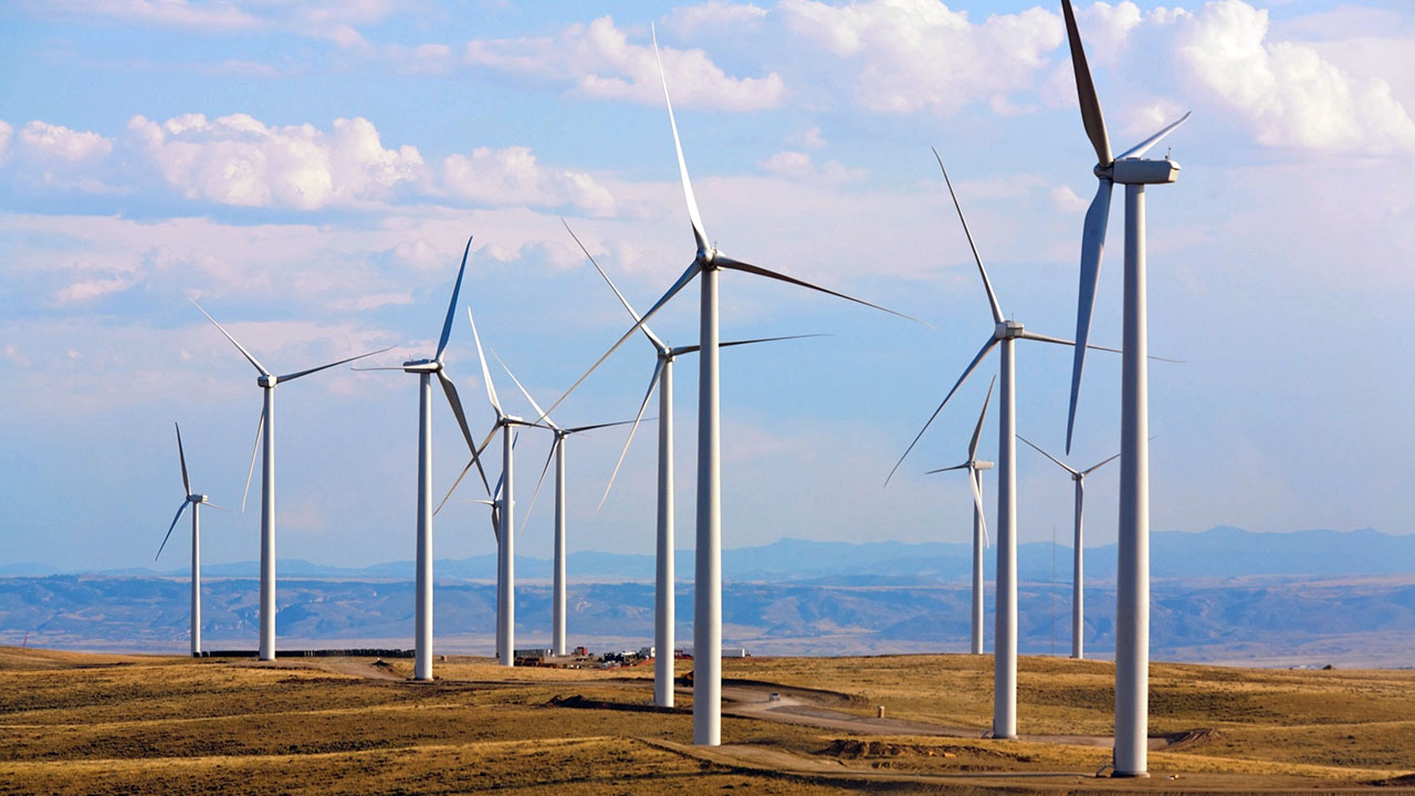 Éoliennes produisant de l’énergie propre installées dans des plaines avec un ciel bleu en arrière-plan