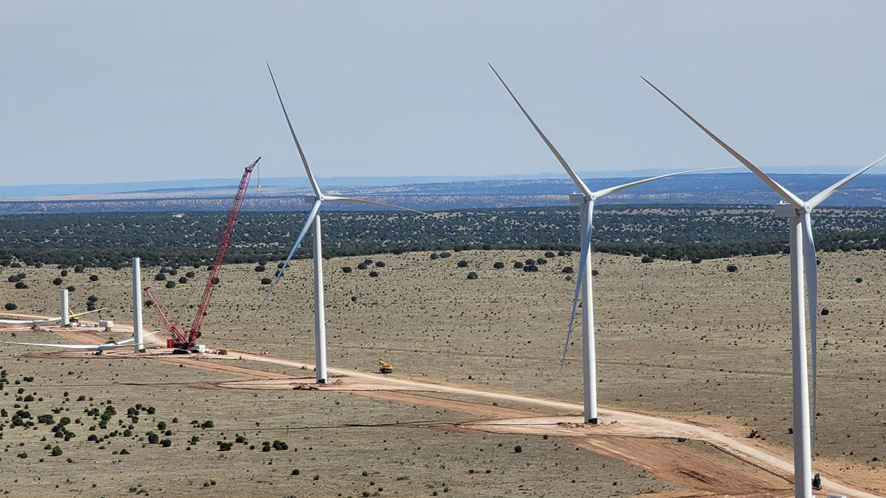Éoliennes en train d’être érigées par une grue rouge dans le désert sur le site d’un projet géré par Tetra Tech