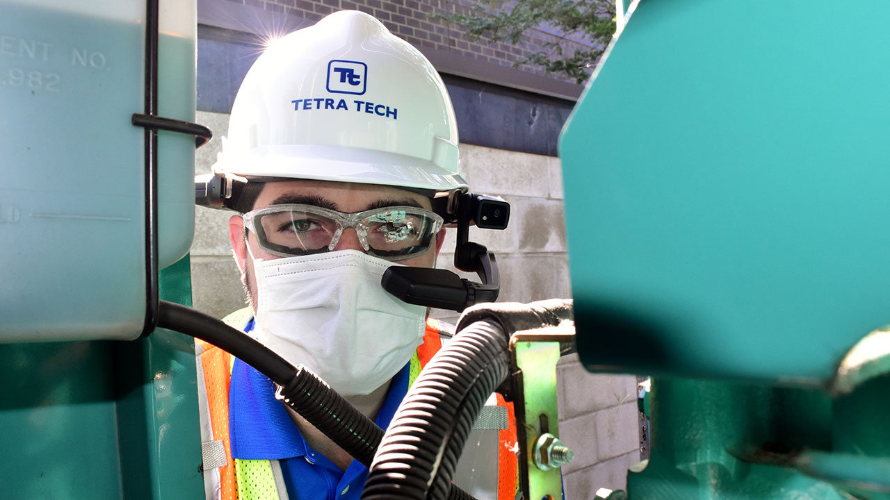 Un employé de Tetra Tech portant un équipement de sécurité pose le temps d’une photo sur le site d’un projet