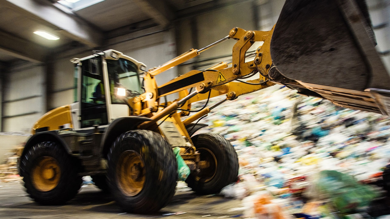 Bouteur en train de déplacer des déchets à l’intérieur d’une station de transfert