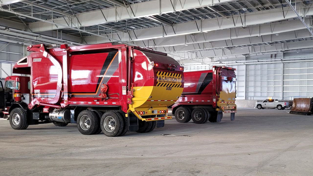 Deux camions à ordures à l’intérieur d’une station de transfert