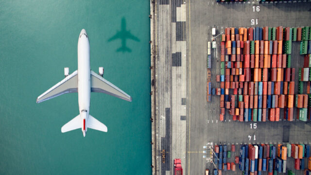 Vue aérienne d’un avion survolant des conteneurs de marchandises dans un port